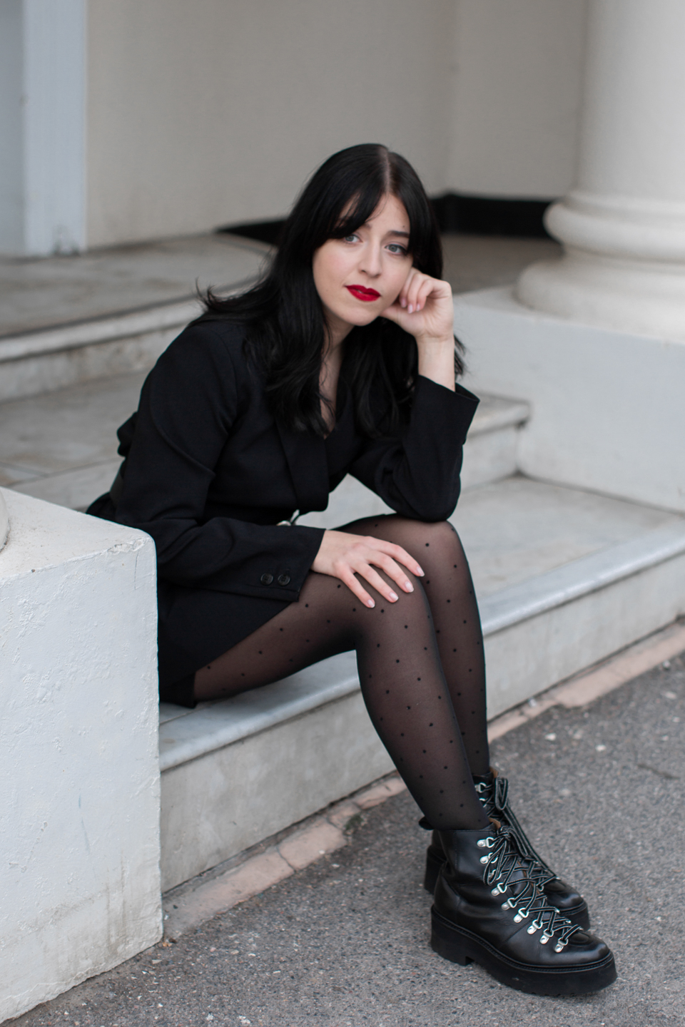 Besma wears Ganni black blazer, dotted tights and black boots