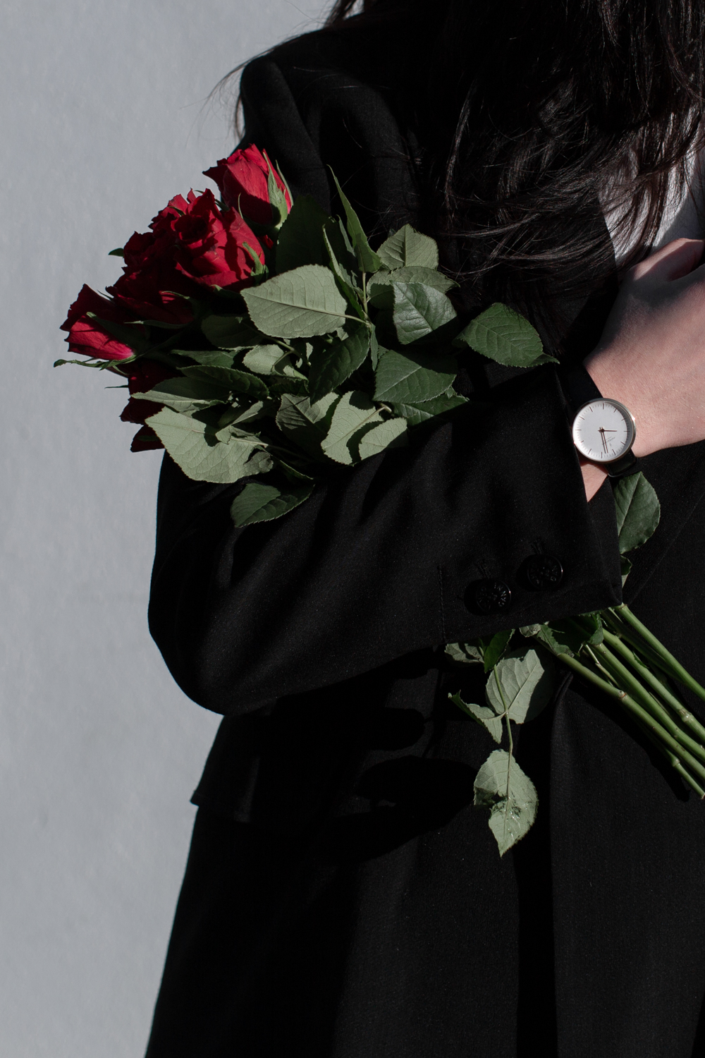 Close-up of roses with watch on wrist