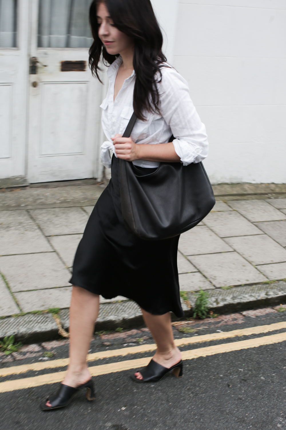Besma walks with slouchy black handbag
