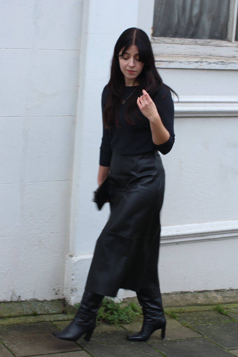Full outfit shot of black sparkle top, black leather midi skirt, black boots