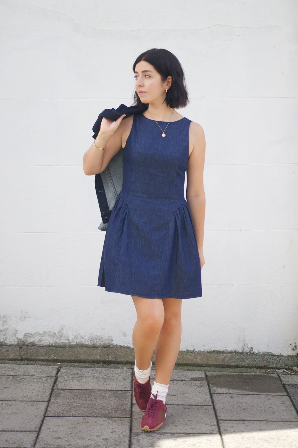 Besma wears denim pinafore dress with sneakers outfit