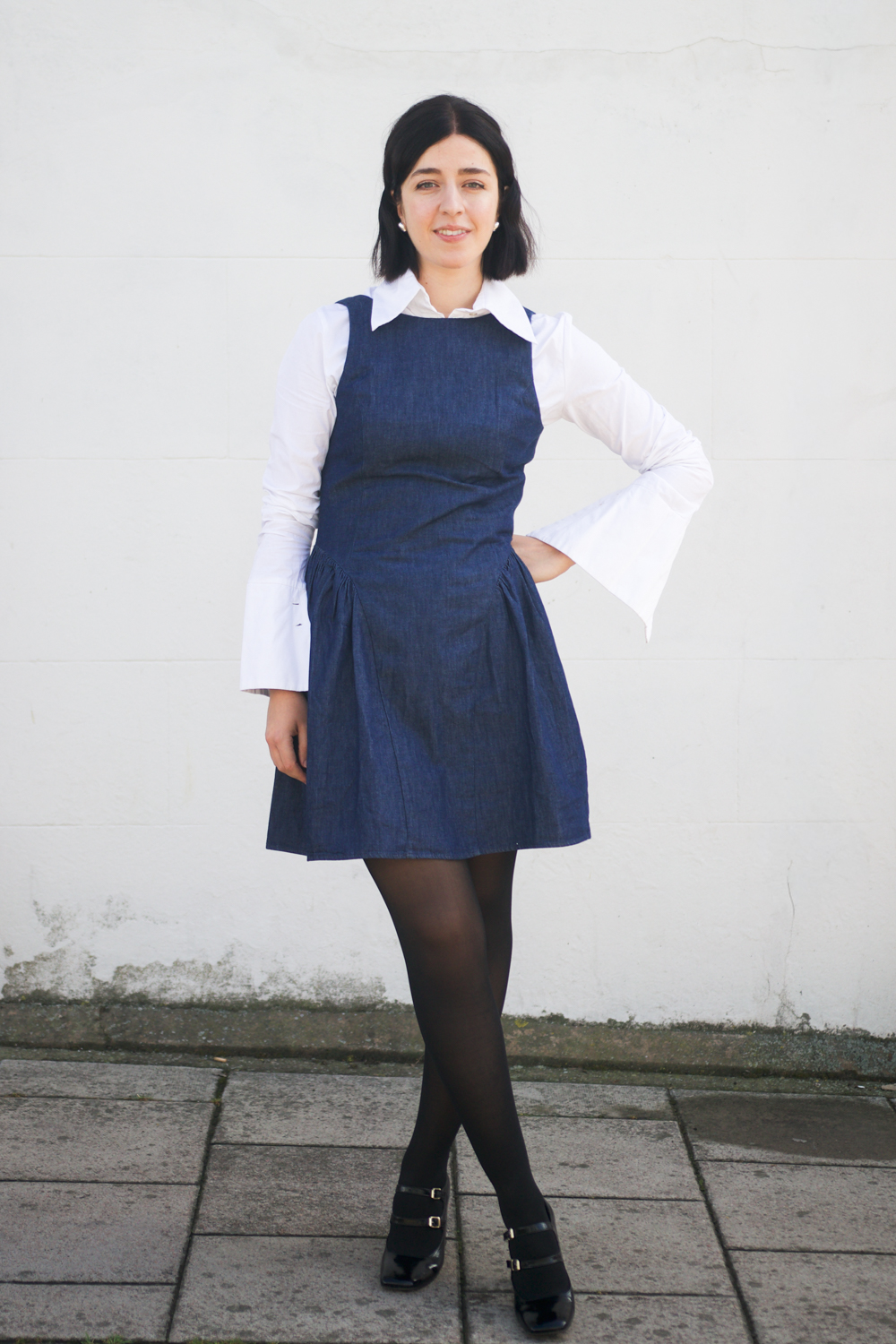 Besma wears denim pinafore dress with white shirt outfit