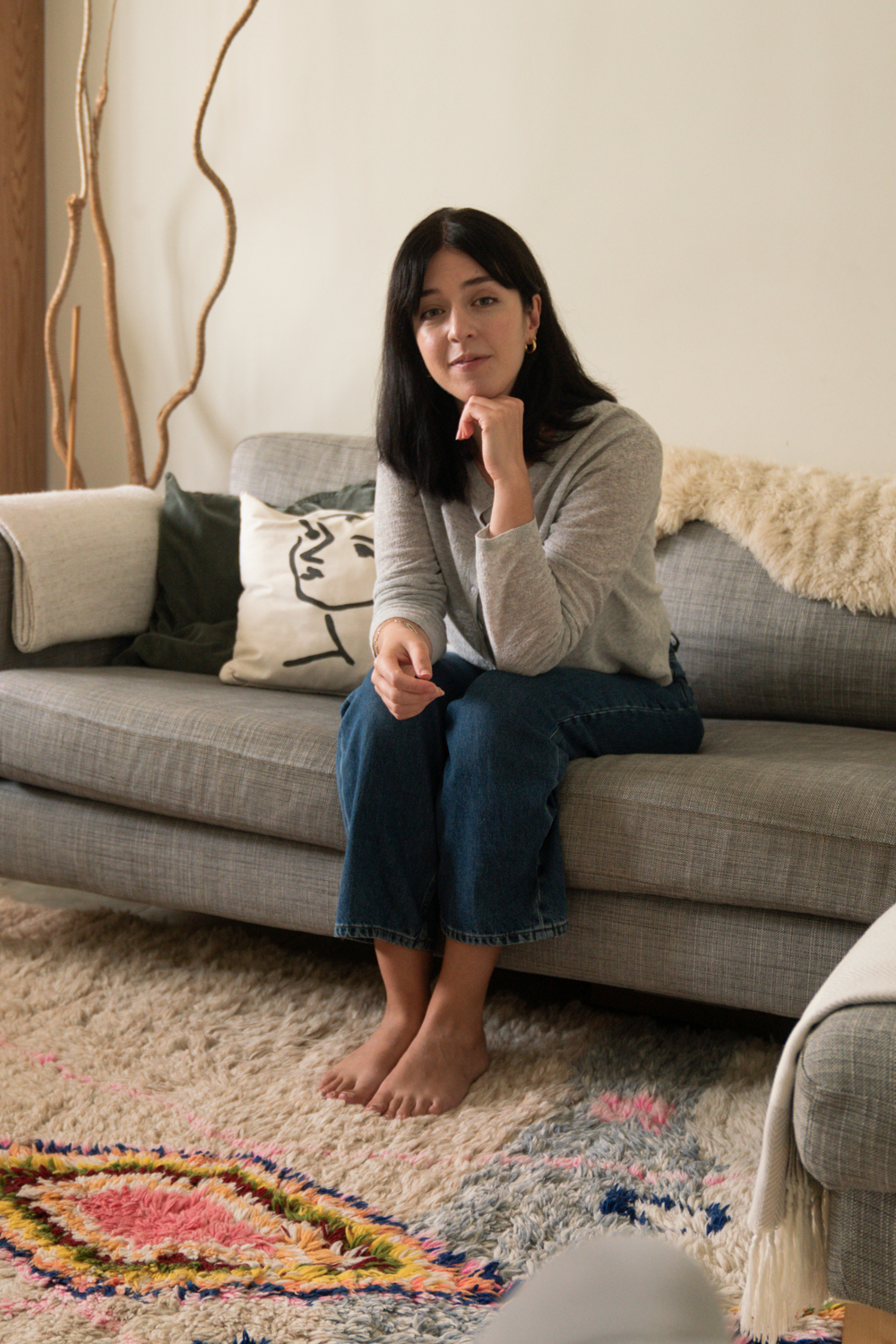 Besma sat on sofa with rug