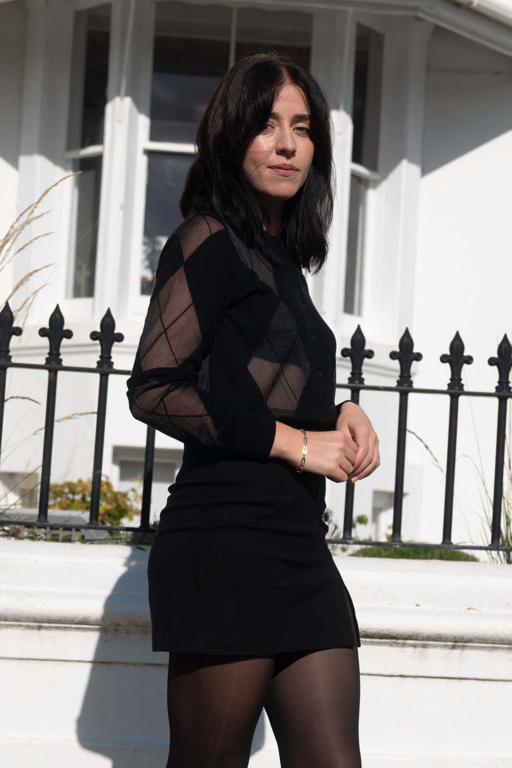 Besma wears black argyle top with black mini skirt